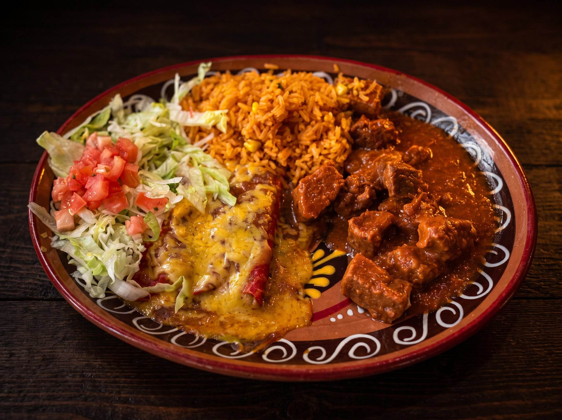 Carne guisada combination plate with rice, an enchilada, lettuce and pico de gallo